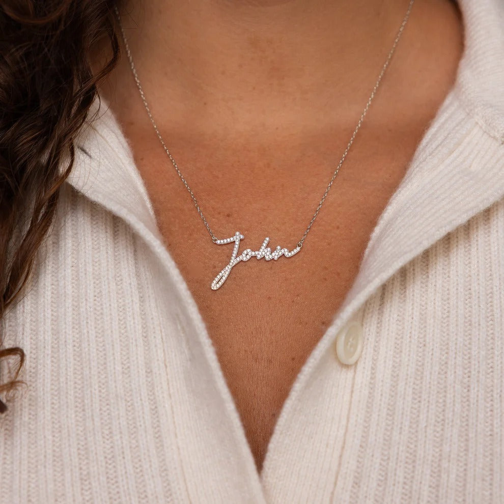 Necklace with 'John' pendant worn by a person in a light-colored sweater.