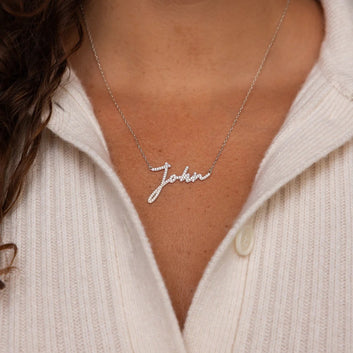 Necklace with 'John' pendant worn by a person in a light-colored sweater.