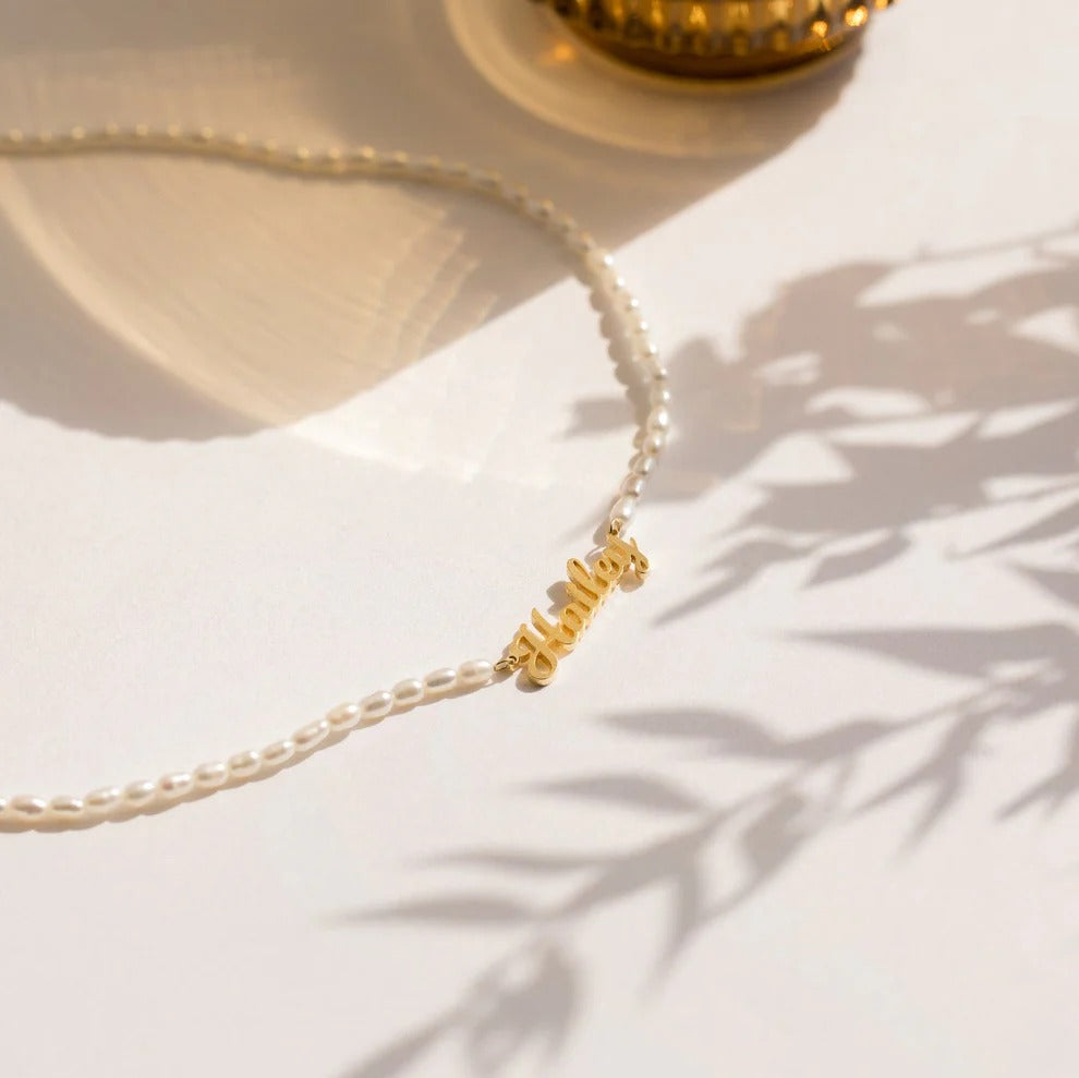 Pearl necklace with a gold clasp on a light background