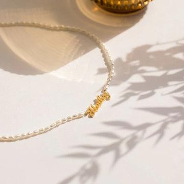 Pearl necklace with a gold clasp on a light background
