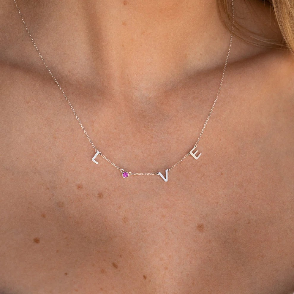 Necklace with 'LOVE' letters on a person's neck