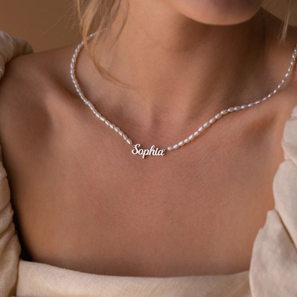 Silver necklace with 'Sophia' pendant on a person wearing a beige top.