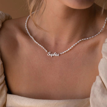 Silver necklace with 'Sophia' pendant on a person wearing a beige top.
