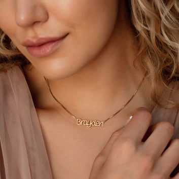 Close-up of a person wearing a gold 'Brayden' necklace.