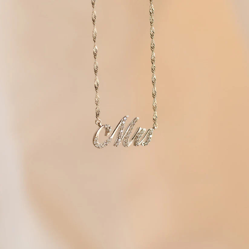 Necklace with 'Mia' pendant on a beige background