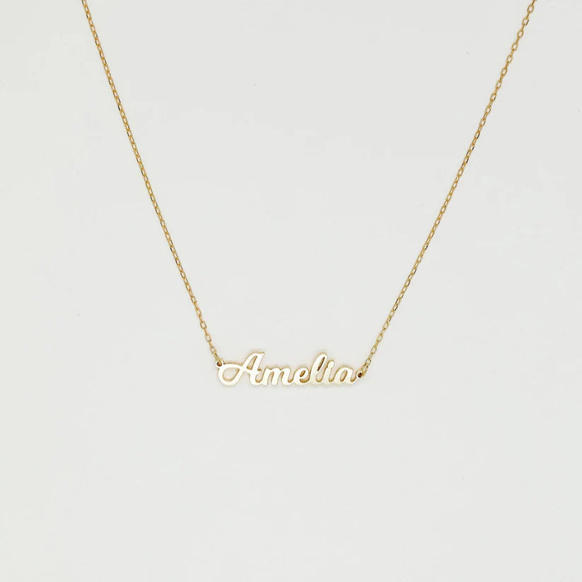 Gold name necklace with 'Amelia' on a light gray background