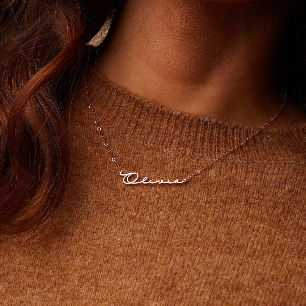 Necklace with 'Olivia' pendant on a brown sweater