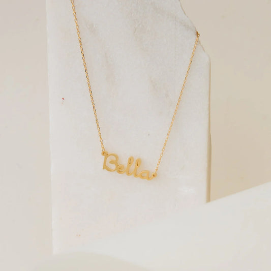 Gold 'Bella' necklace on a white marble surface