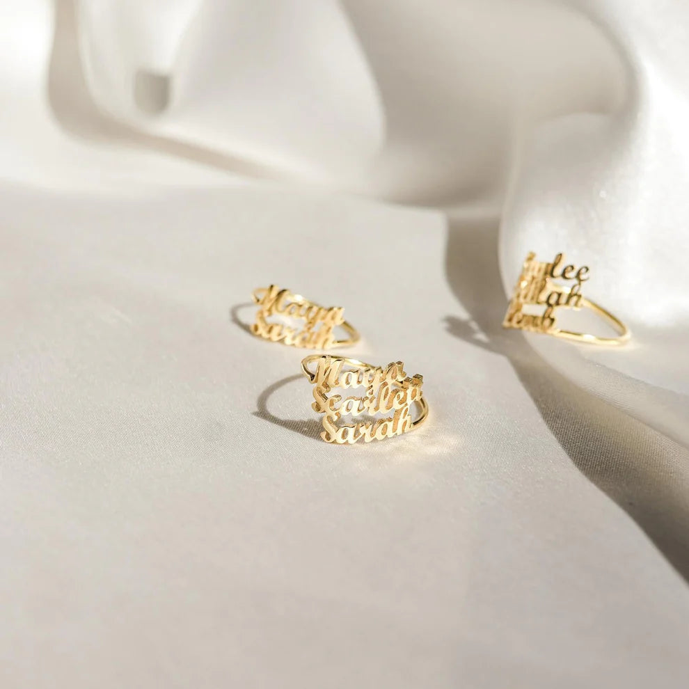 Gold name ring set on a white surface