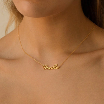 Gold necklace with 'Pricilla' pendant on a person's neck