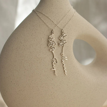 Gold necklace and earrings on a mannequin bust with a neutral background