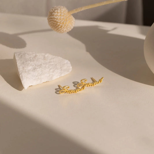 Gold necklace on a textured beige surface with a decorative flower.