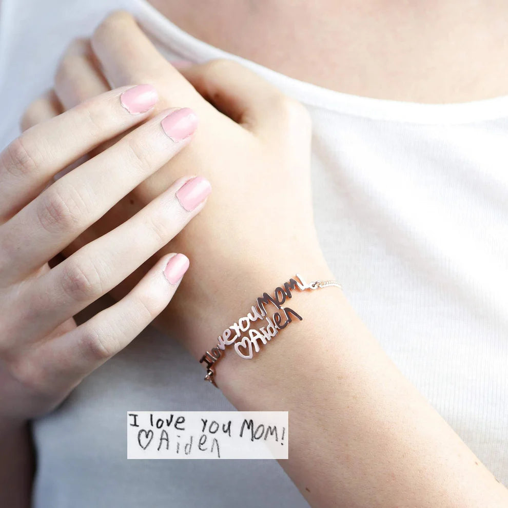 Person wearing a bracelet with 'I love you Mom' on a white background