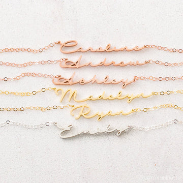 Set of gold name necklaces on a light background