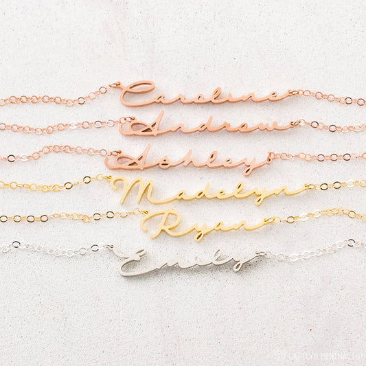 Set of gold name necklaces on a light background