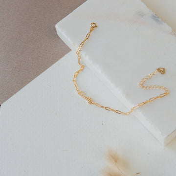 Gold chain bracelet on a marble surface
