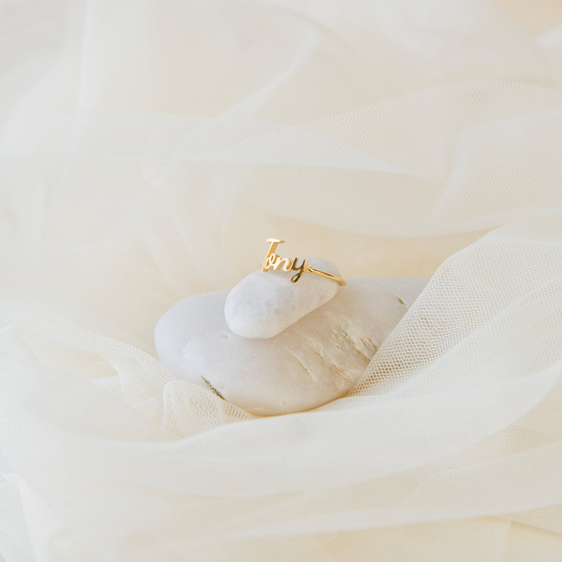 Gold ring with 'amy' engraving on a white surface